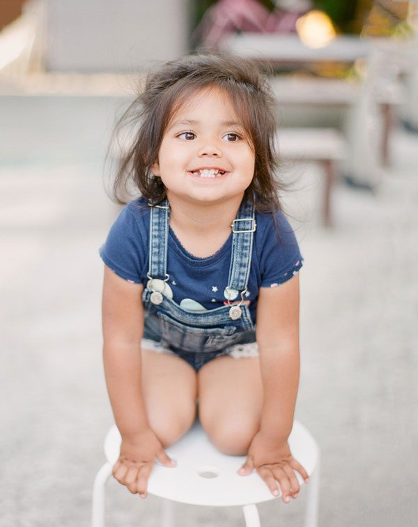 Little girl smiling while climbing an obstacle 