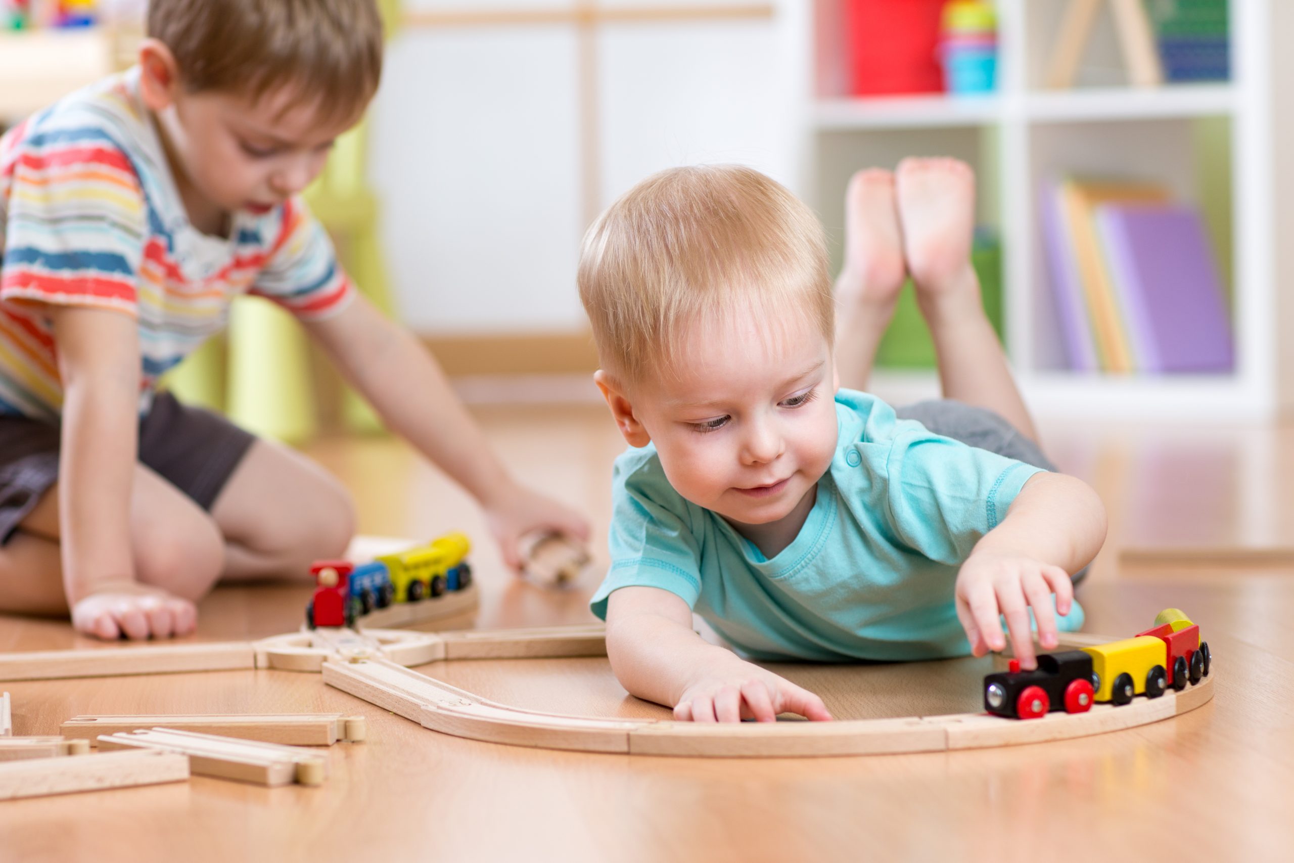 Little boys playing with wooden train set